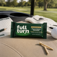 Full Turn peanut butter chocolate bar on a golf cart with golf accessories in the background